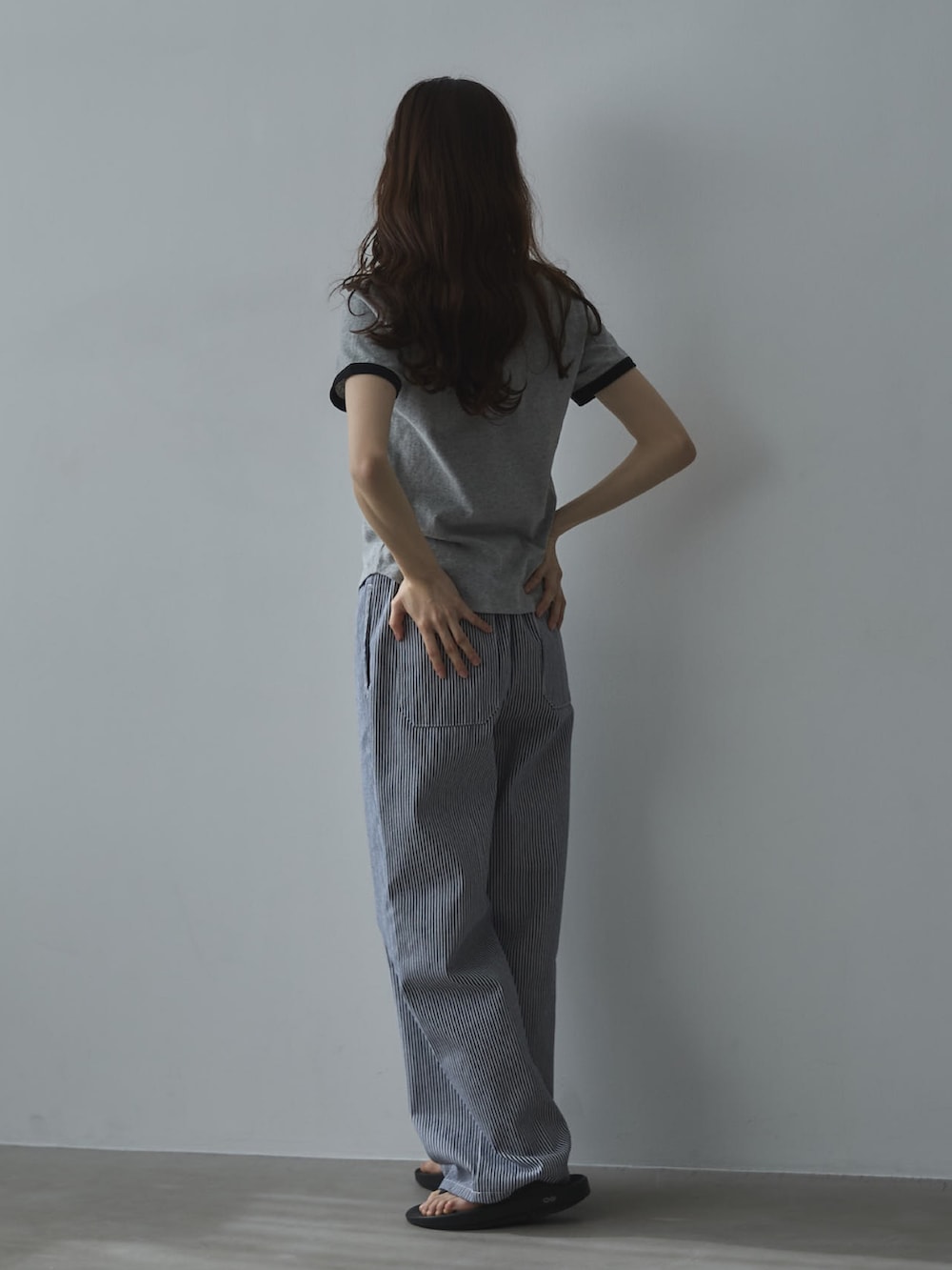 グレー系のTシャツ/カットソー、ホワイト系のデニムパンツ、ブラック系のサンダルを着用したレディースの夏コーディネートの2枚目の写真