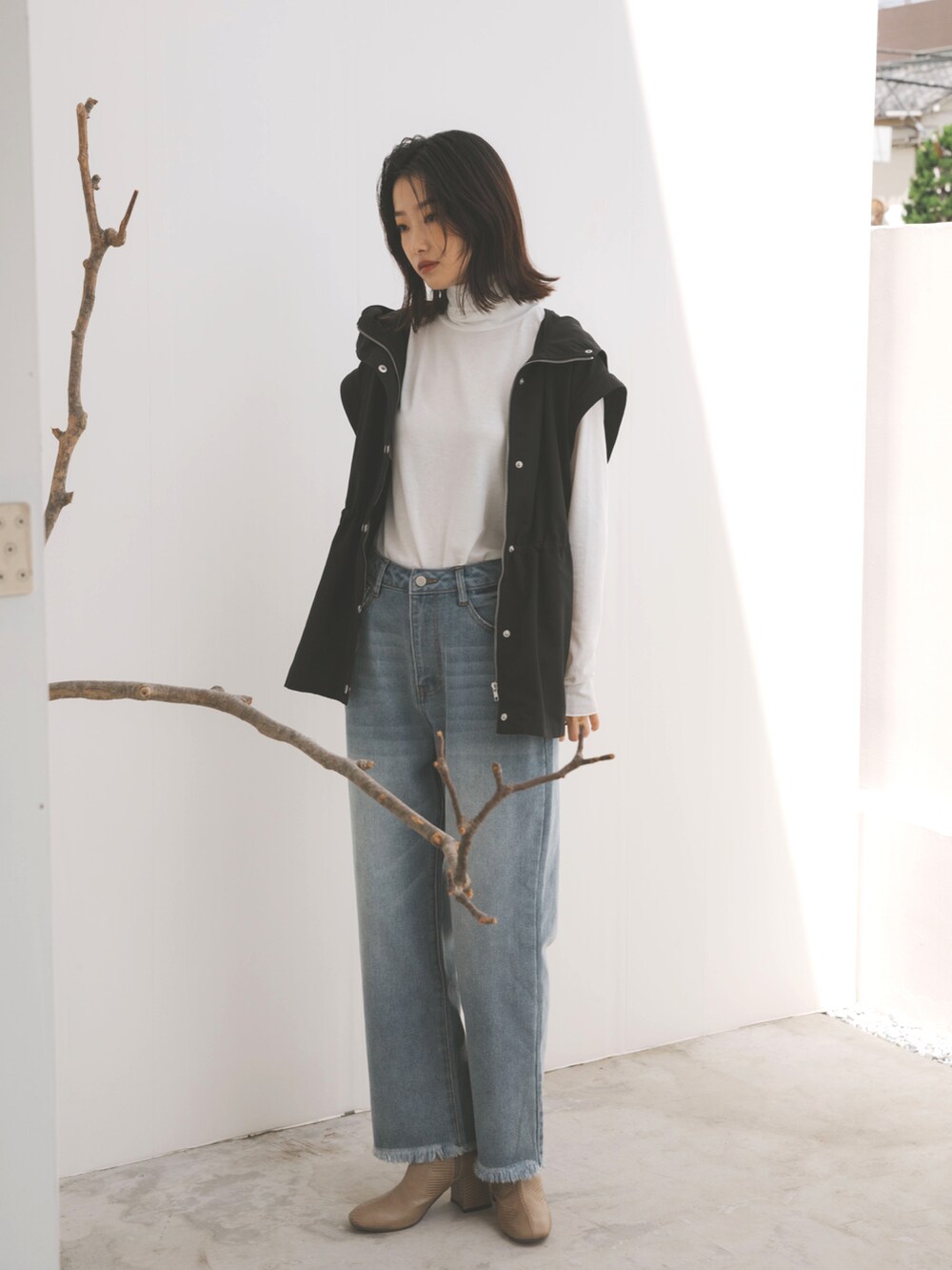 ブラック系のマウンテンパーカー、ブルー系のデニムパンツ、ホワイト系のTシャツ/カットソーを着用したレディースの秋コーディネートの3枚目の写真