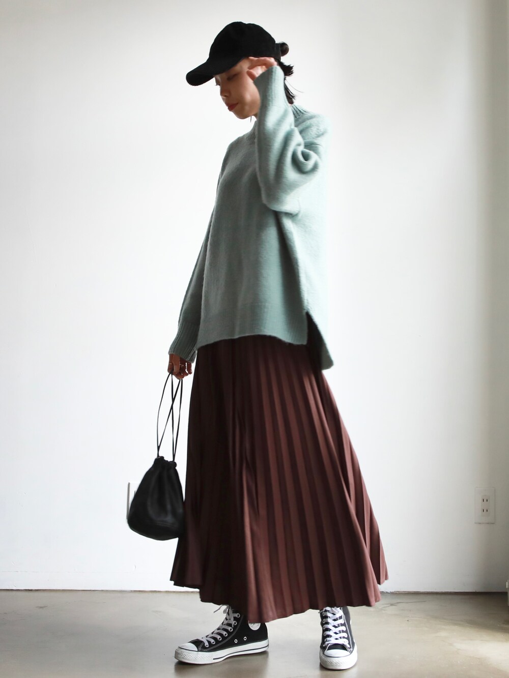 ブルー系のニット/セーター、ブラウン系のスカート、ブラック系のスニーカーを着用したレディースの冬コーディネートの2枚目の写真