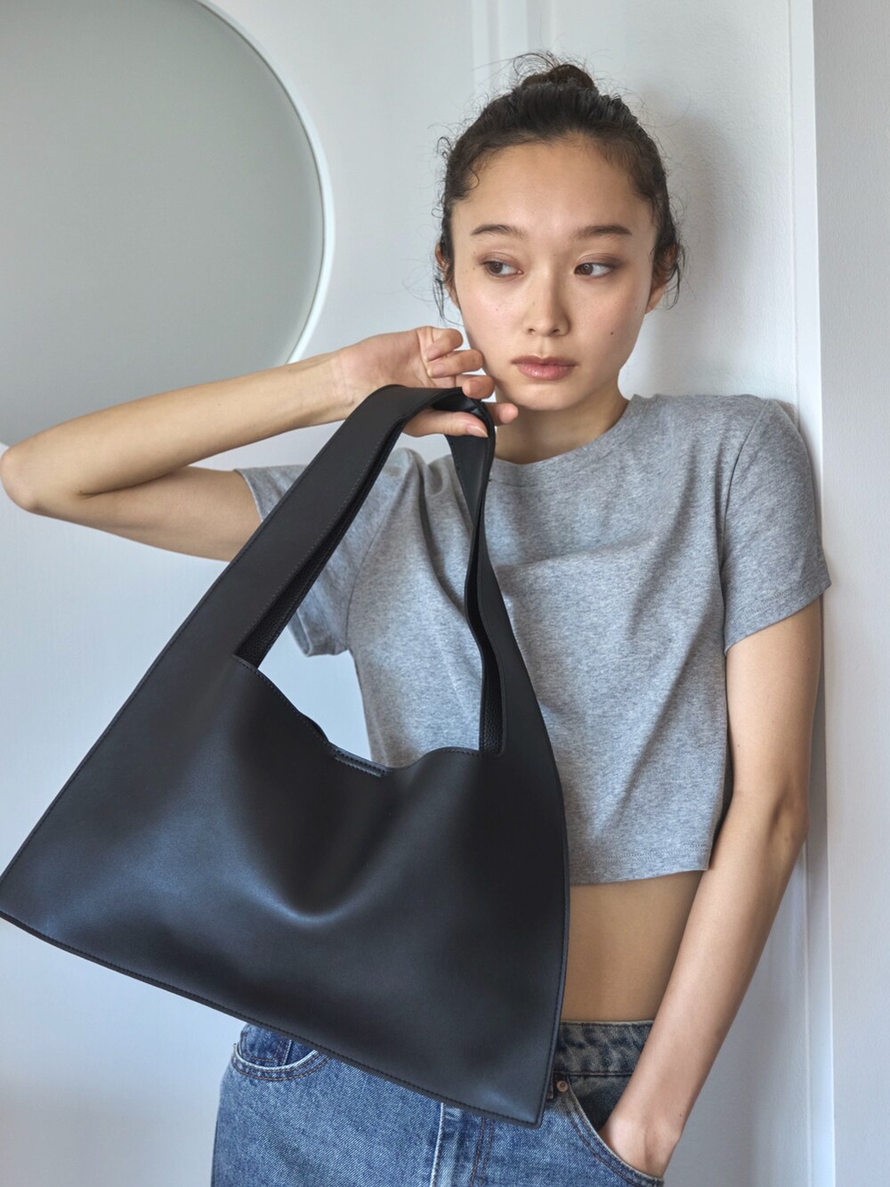 グレー系のTシャツ/カットソー、ブルー系のデニムパンツ、ベージュ系のスニーカーを着用したレディースの夏コーディネートの5枚目の写真