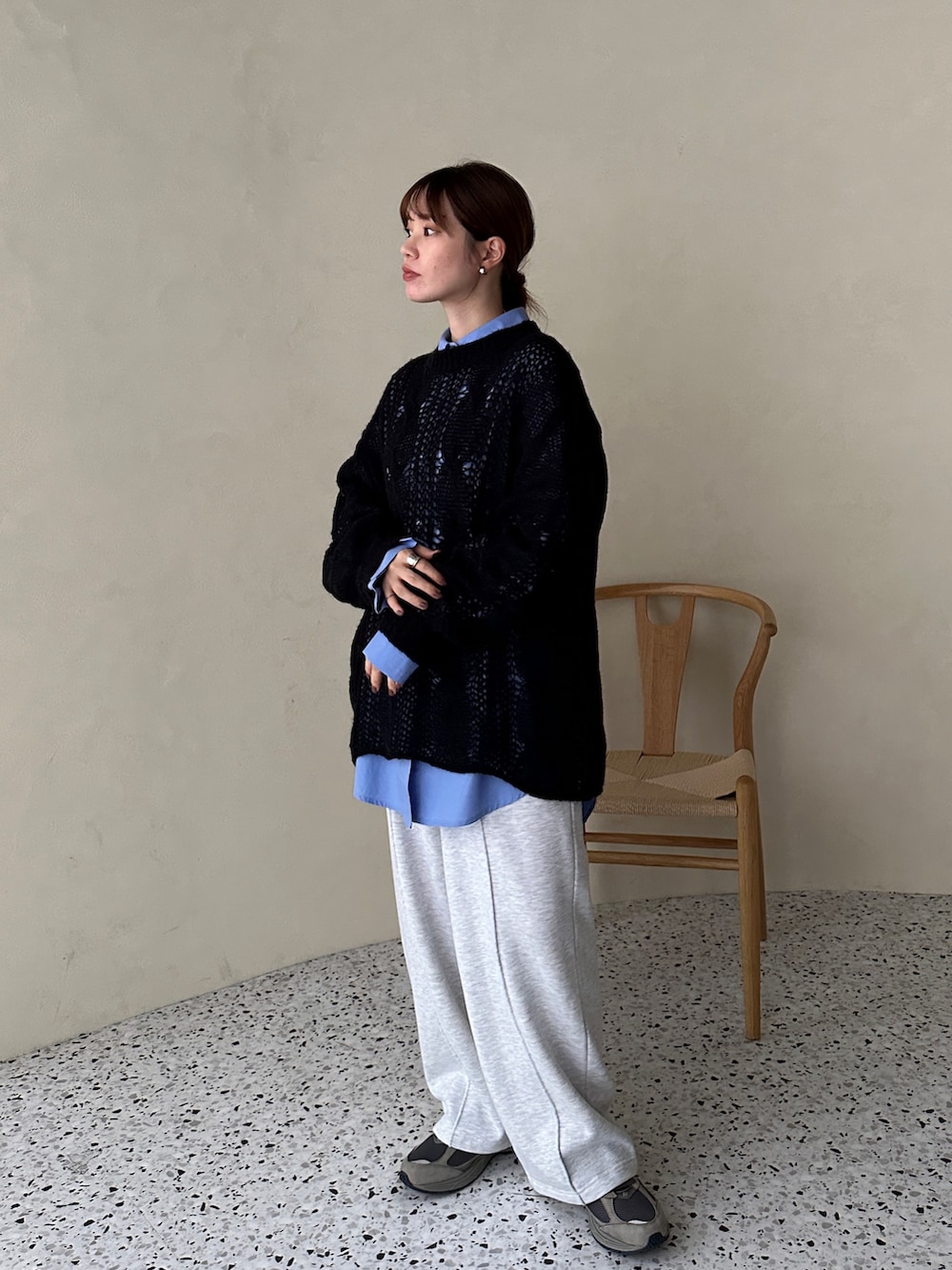 ブラック系のニット/セーター、ブルー系のシャツ/ブラウス、ベージュ系のスウェットパンツを着用したレディースの秋コーディネートの2枚目の写真
