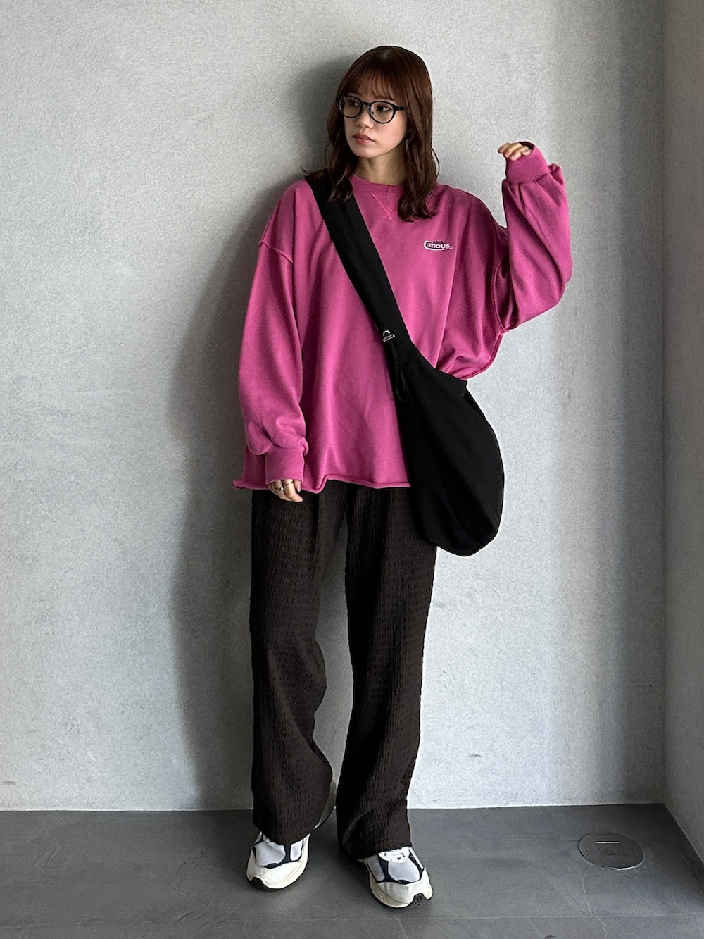 ピンク系のスウェット、ホワイト系のショルダーバッグ、ホワイト系のスニーカーを着用したレディースの冬コーディネートの2枚目の写真