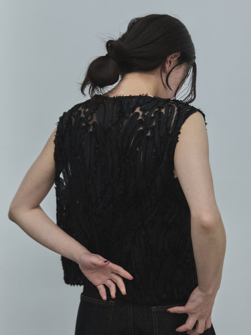 ブラック系のベスト、ブラック系のデニムパンツ、ブラック系のサンダルを着用したレディースの夏コーディネートの5枚目の写真