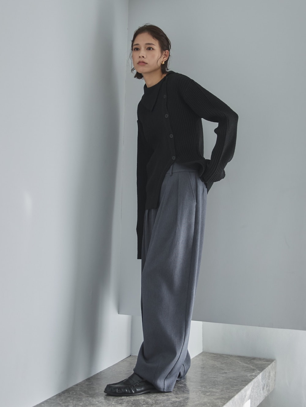 ブラック系のニット/セーター、グレー系のスラックス、その他のその他を着用したレディースの冬コーディネートの2枚目の写真