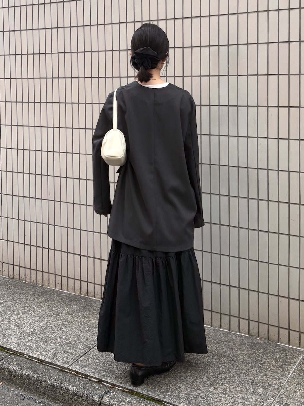 グレー系のその他トップス、ホワイト系のTシャツ/カットソー、ブラック系のスカートを着用したレディースの春コーディネートの3枚目の写真