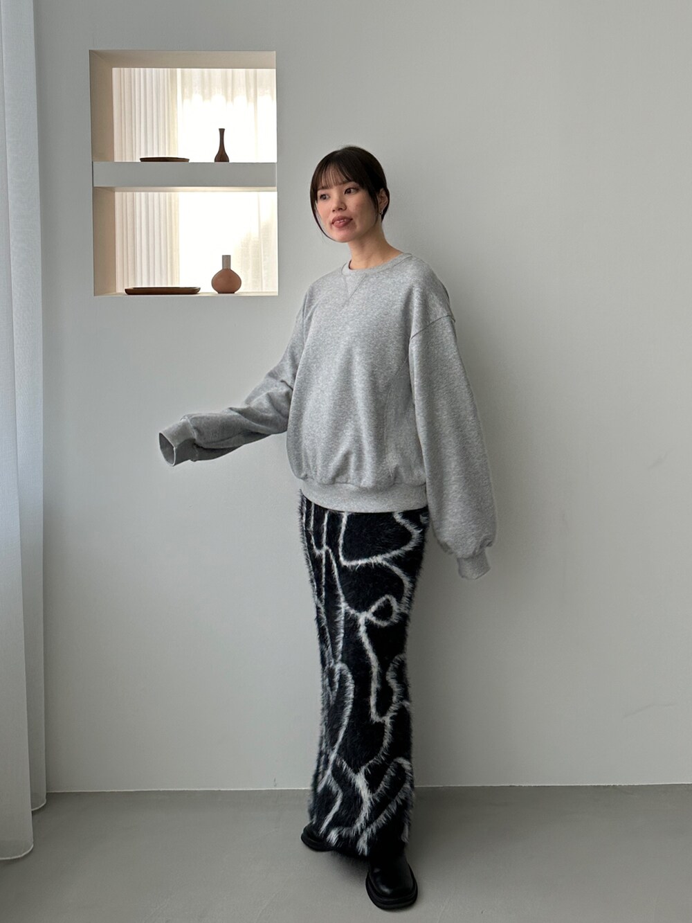 ホワイト系のニット/セーター、ブラウン系のスカート、ブラック系のスカートを着用したレディースの冬コーディネートの3枚目の写真