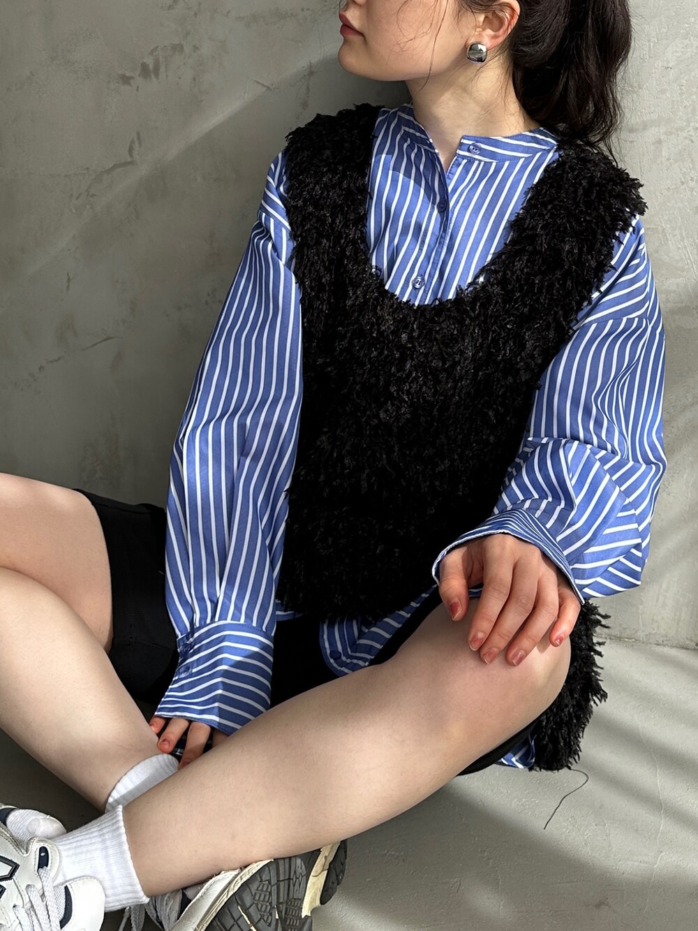 ブラック系のベスト、ブルー系のシャツ/ブラウス、ブラック系のその他パンツを着用したレディースの春コーディネートの3枚目の写真