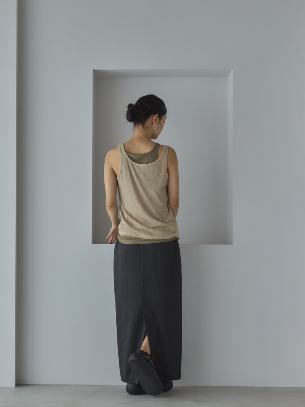 ベージュ系のタンクトップ、グレー系のスカート、ブラック系のサンダルを着用したレディースの春コーディネートの3枚目の写真