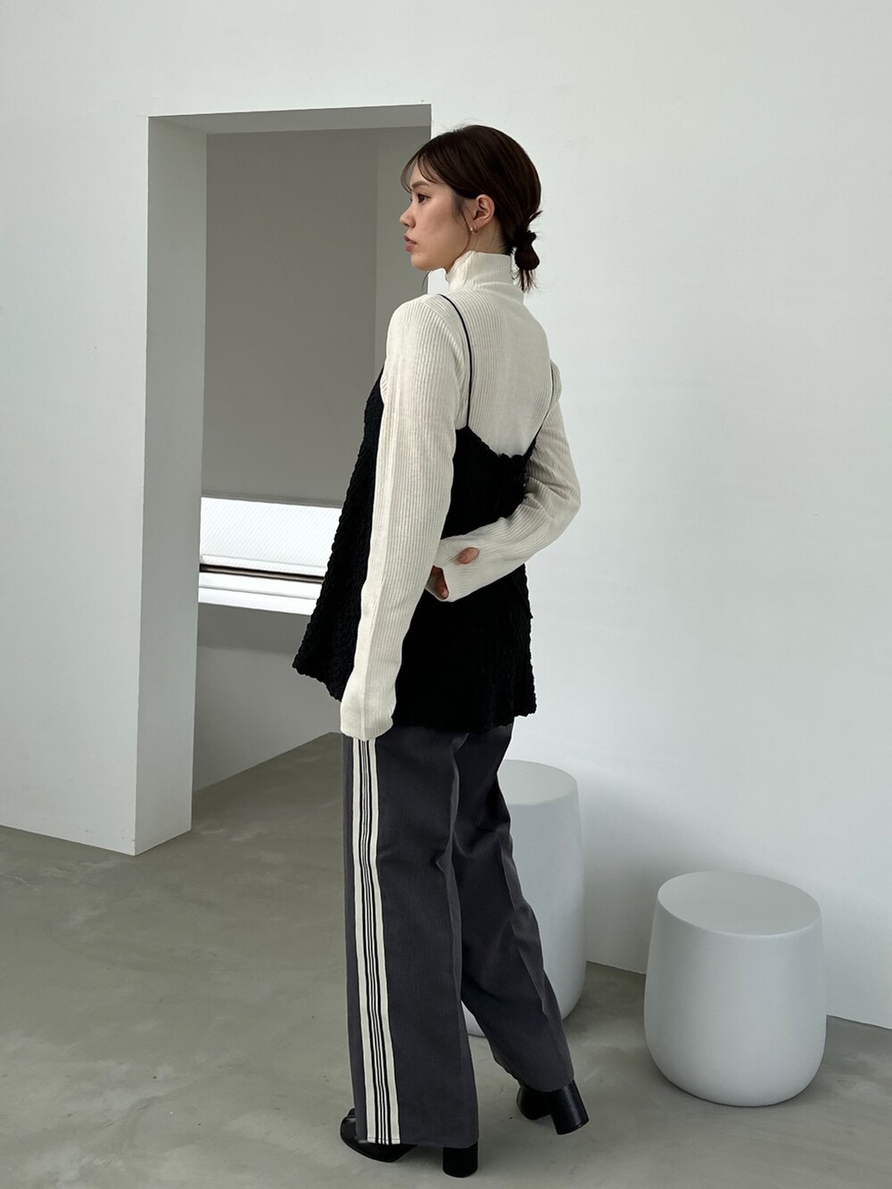 ブラック系のシャツ/ブラウス、グレー系のスラックス、ブラック系のブーツを着用したレディースの秋コーディネートの2枚目の写真