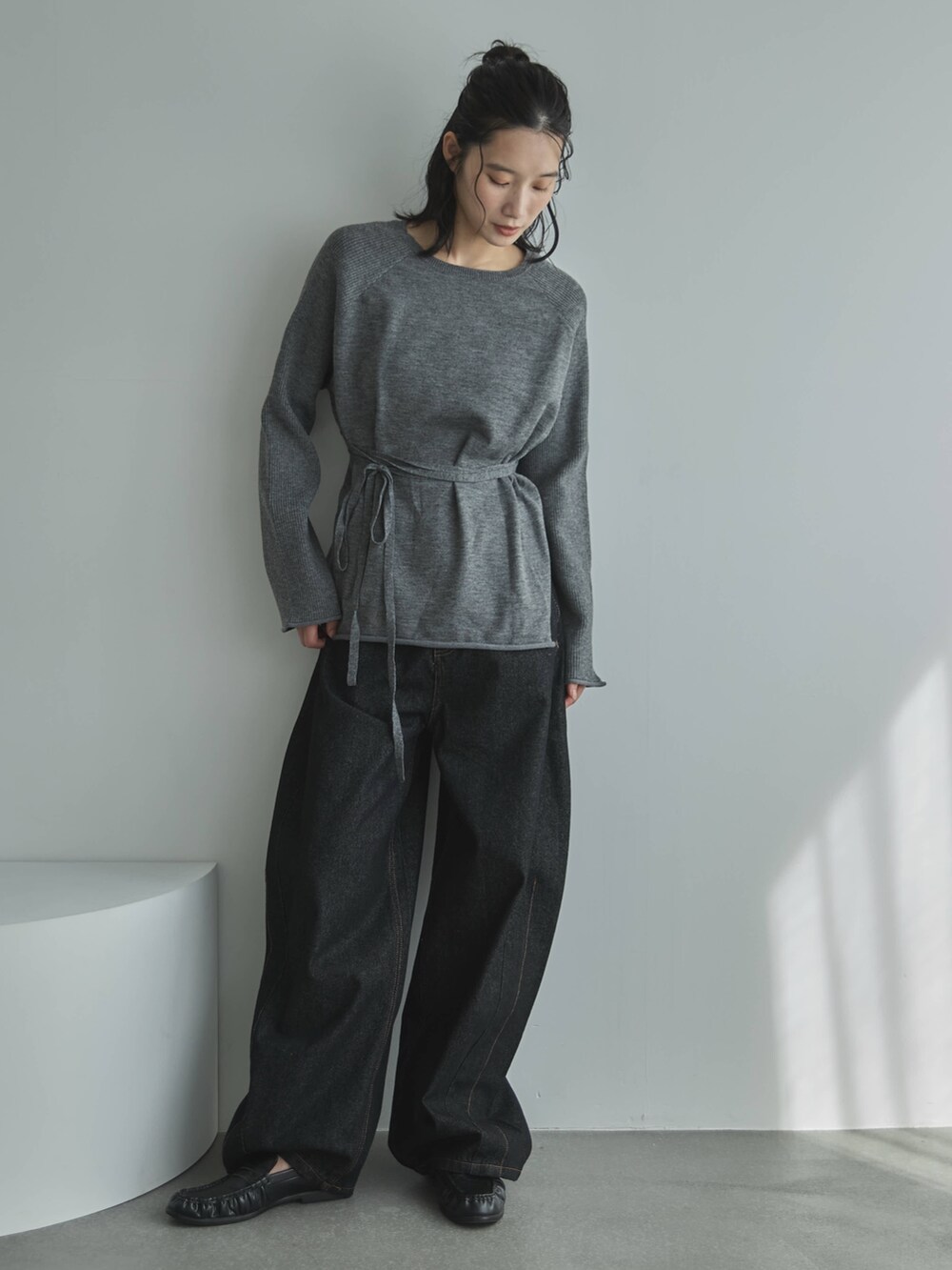 グレー系のニット/セーター、ブラック系のデニムパンツ、その他のその他を着用したレディースの秋コーディネートの3枚目の写真