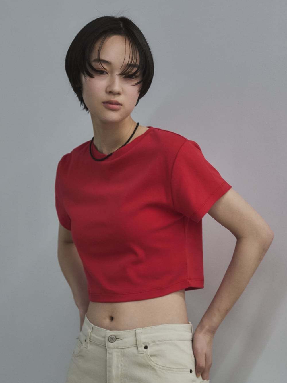 レッド系のTシャツ/カットソー、ホワイト系のデニムパンツ、ベージュ系のサンダルを着用したレディースの春コーディネートの5枚目の写真