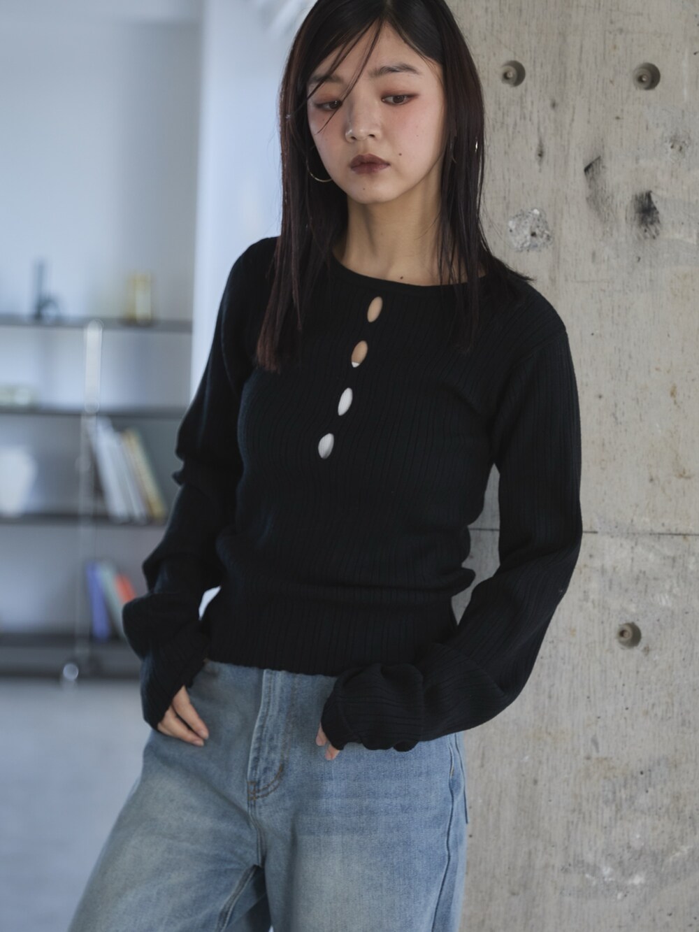 ブラック系のニット/セーター、ブラック系のスリッポン、ブルー系のデニムパンツを着用したレディースの冬コーディネートの4枚目の写真