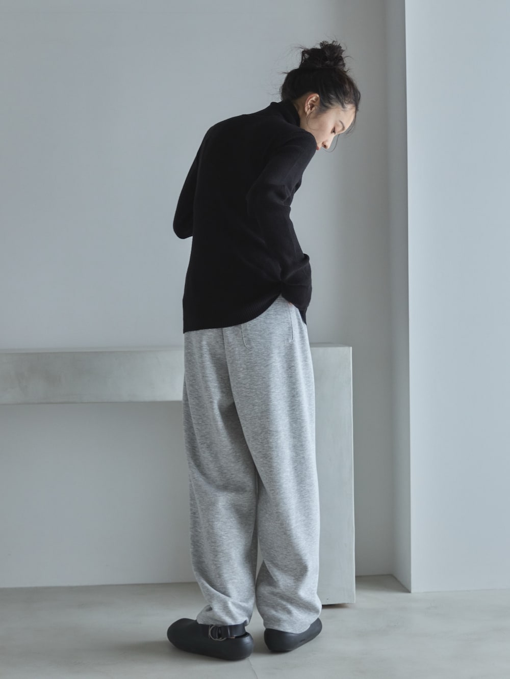 ブラック系のニット/セーター、グレー系のその他パンツ、ブラック系のサンダルを着用したレディースの秋コーディネートの3枚目の写真