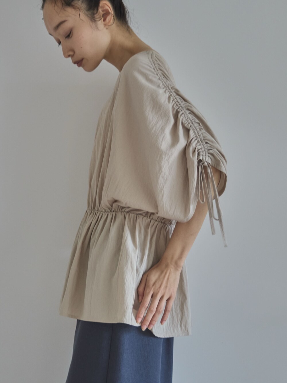 ホワイト系のシャツ/ブラウス、グレー系のスカート、ブラック系のサンダルを着用したレディースの夏コーディネートの4枚目の写真