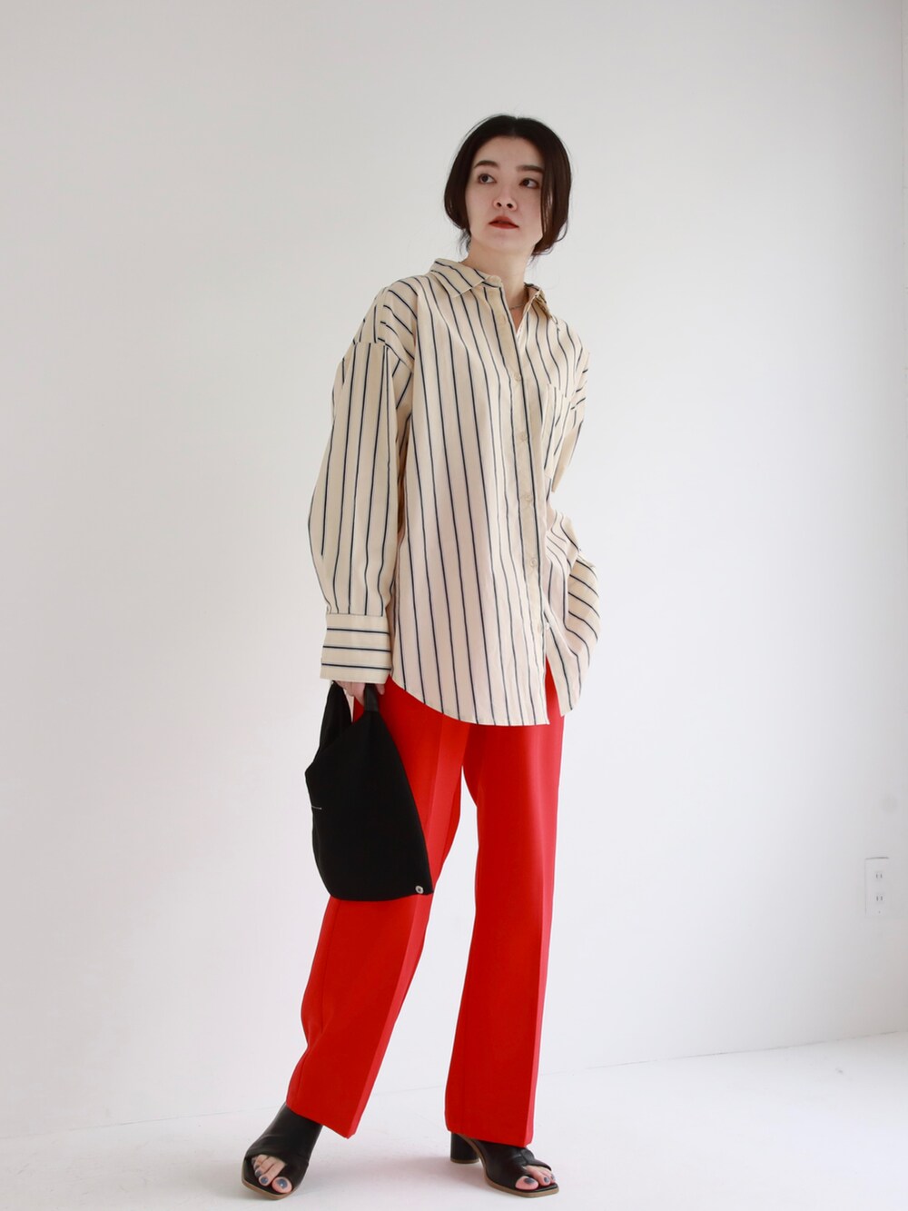 ブラック系のハンドバッグ、ブルー系のデニムパンツ、ピンク系のシャツ/ブラウスを着用したレディースの冬コーディネートの4枚目の写真