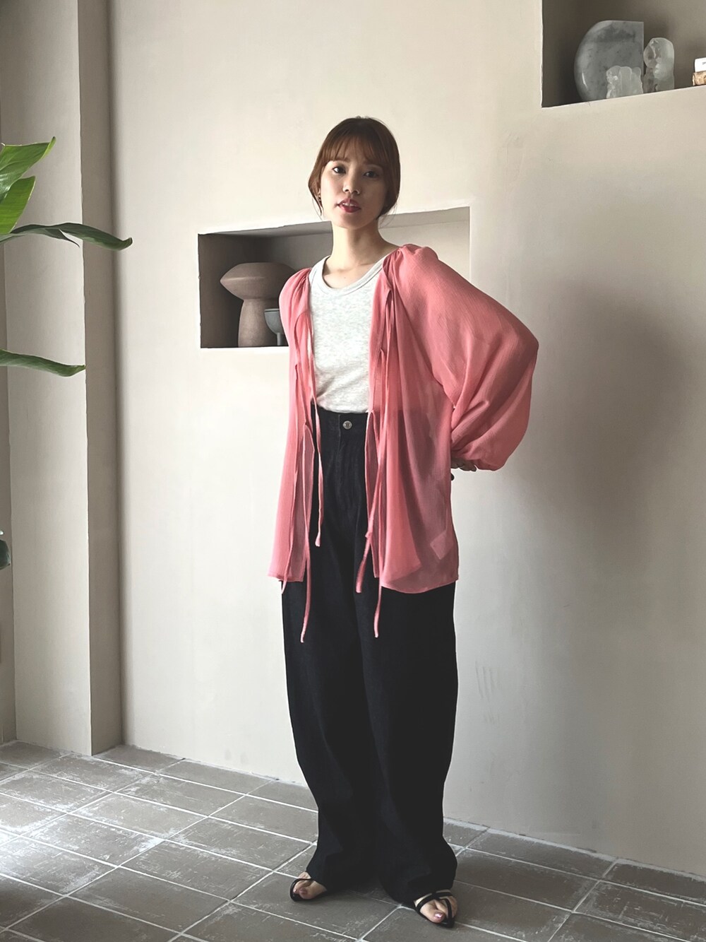 ブラック系のデニムパンツ、ブラック系のサンダル、ベージュ系のタンクトップを着用したレディースの春コーディネートの2枚目の写真