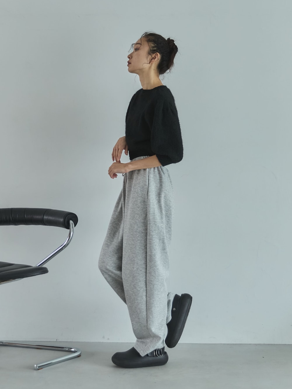 ブラック系のニット/セーター、グレー系のその他パンツ、ブラック系のサンダルを着用したレディースの秋コーディネートの2枚目の写真