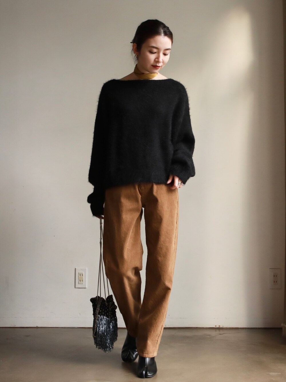 ベージュ系のその他パンツ、ブラック系のブーツ、ブラック系のニット/セーターを着用したレディースの秋コーディネートの2枚目の写真