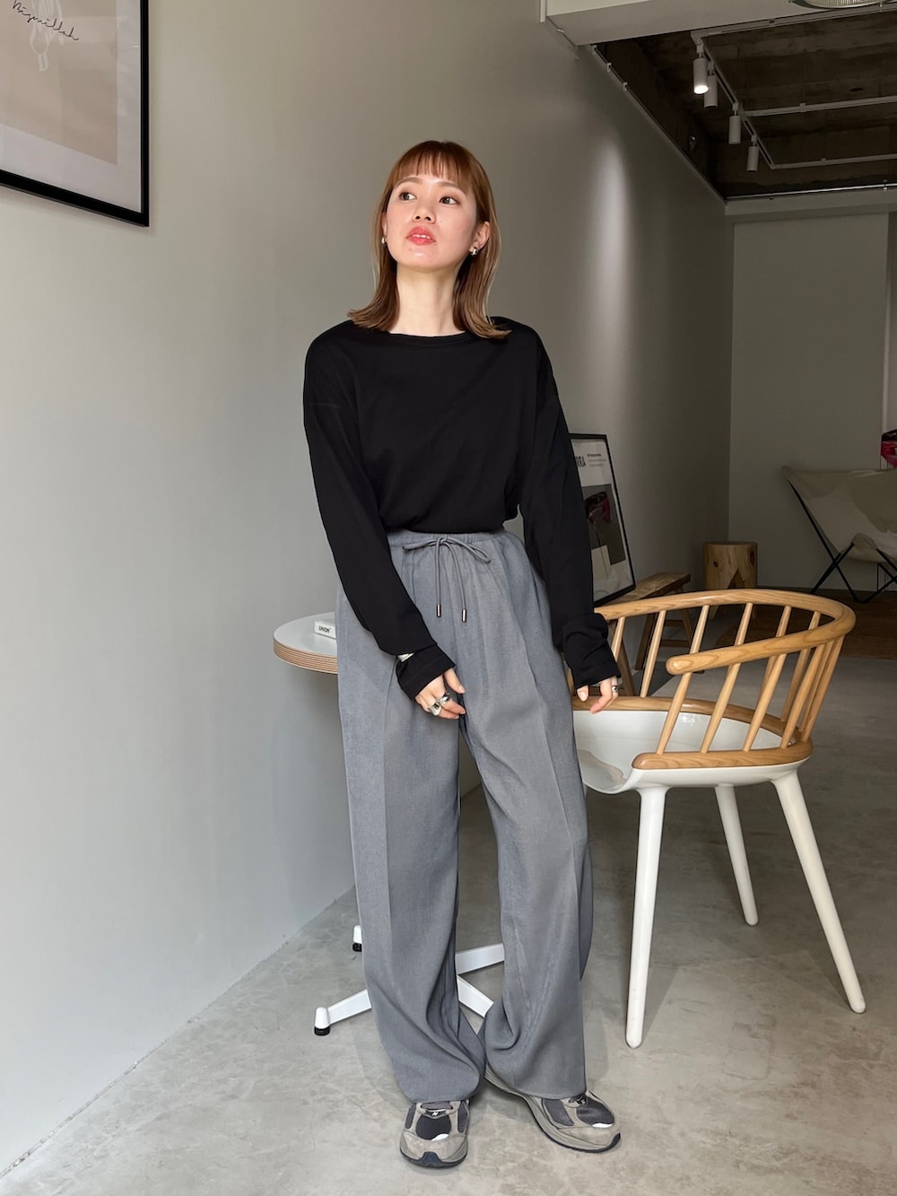 ブラック系のスラックス、ブラック系のサンダル、グレー系のニット/セーターを着用したレディースの春コーディネートの3枚目の写真