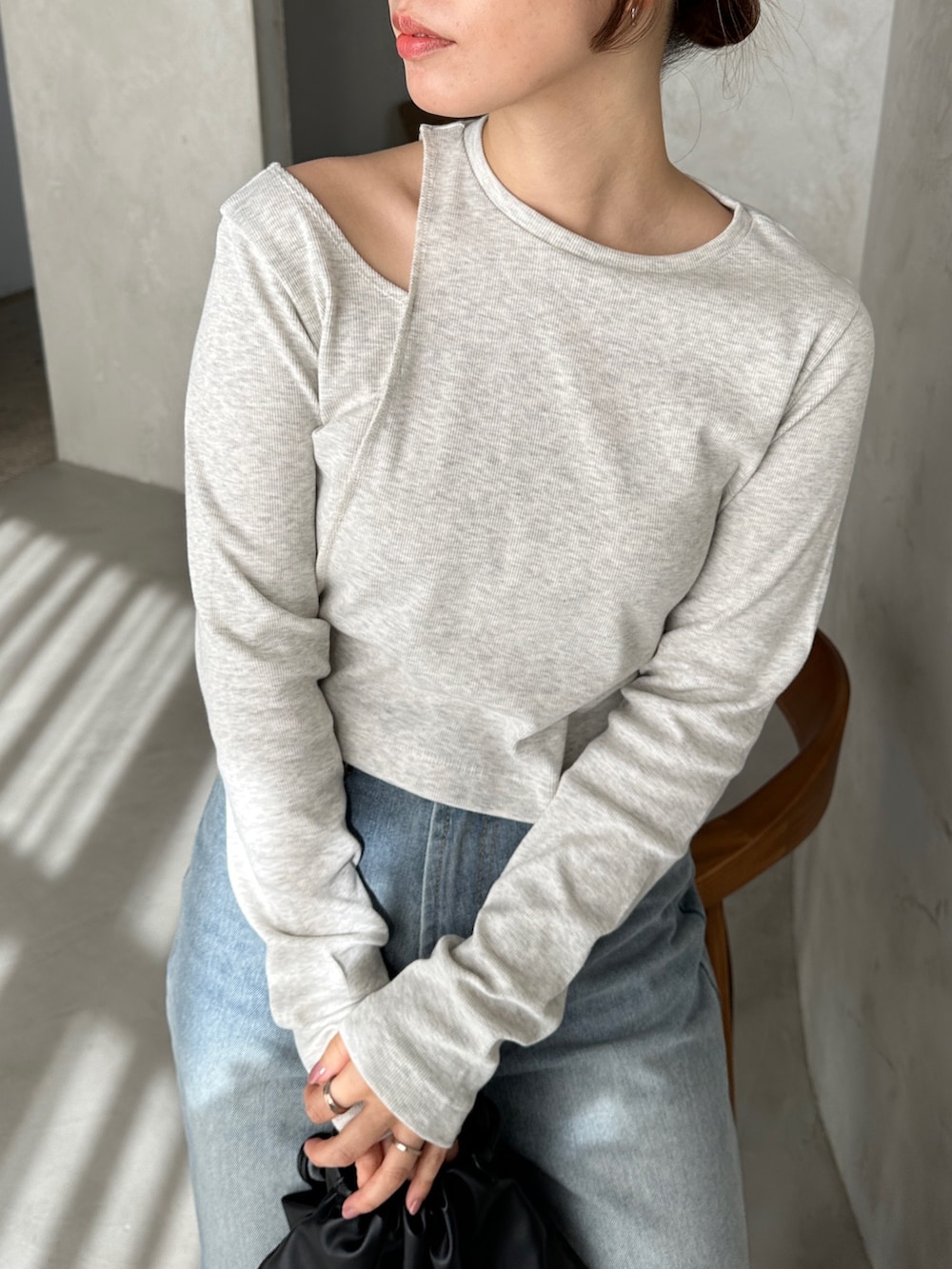 ベージュ系のTシャツ/カットソー、ブルー系のデニムパンツ、ブラック系のショルダーバッグを着用したレディースの冬コーディネートの3枚目の写真