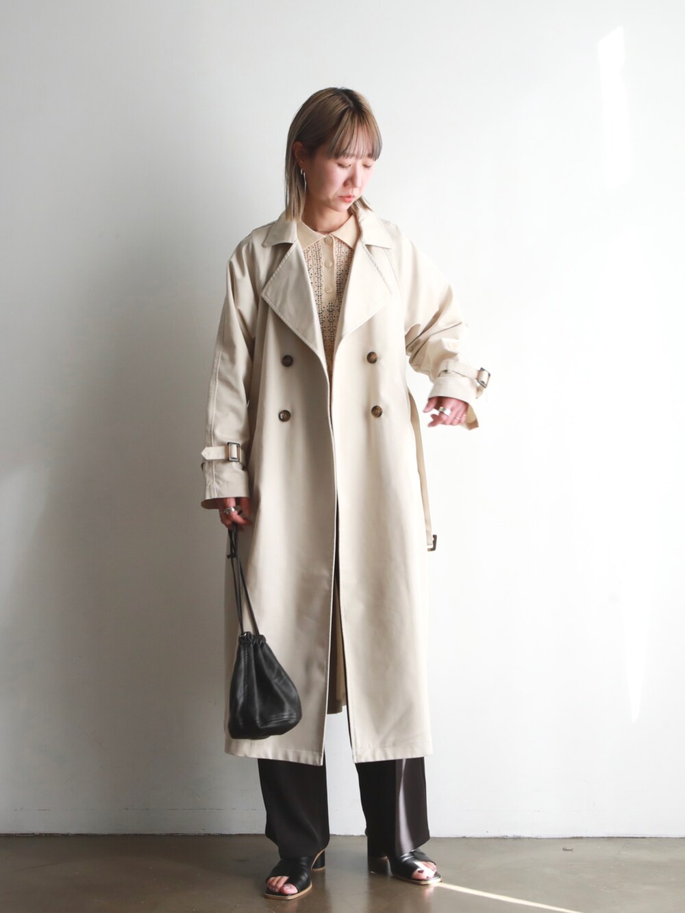 ブラック系のローファー、ホワイト系のトレンチコート、グリーン系のカーディガン/ボレロを着用したレディースの春コーディネートの5枚目の写真