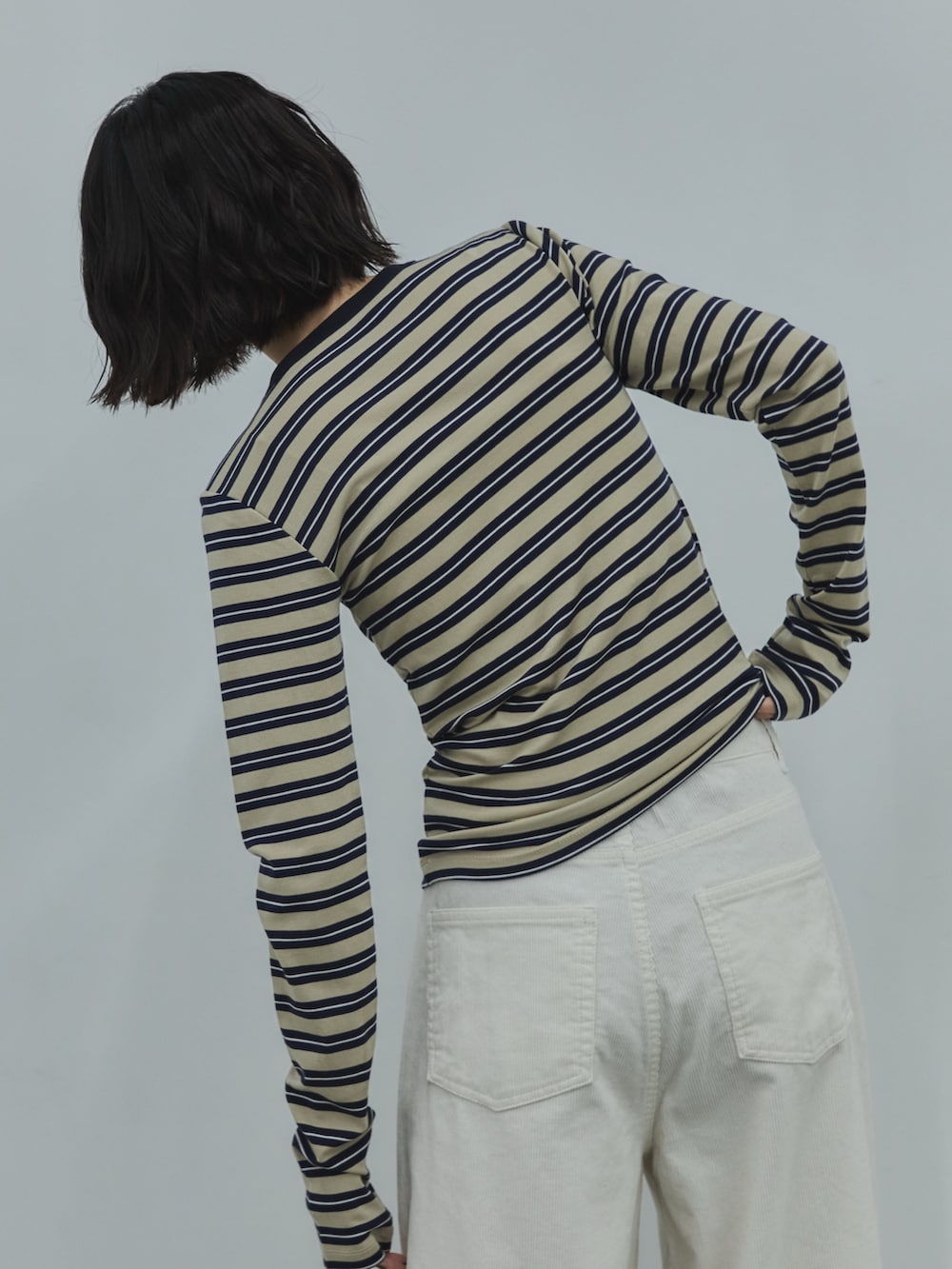 ベージュ系のTシャツ/カットソー、ホワイト系のデニムパンツ、ブラック系のローファーを着用したレディースの秋コーディネートの3枚目の写真