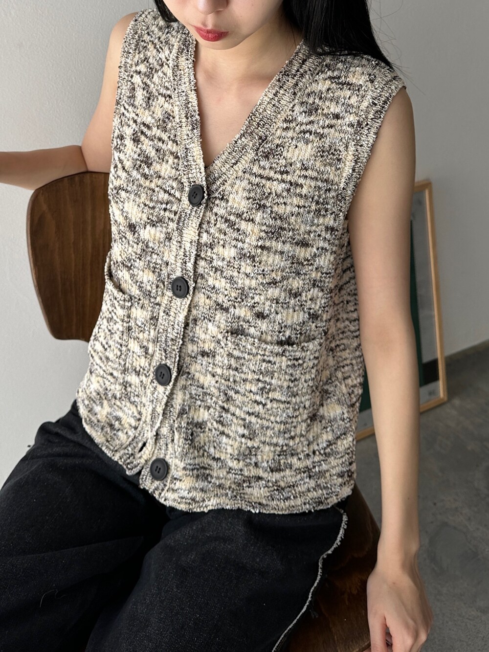 ブラック系のベスト、ブラック系のデニムパンツ、ブラック系のサンダルを着用したレディースの夏コーディネートの3枚目の写真