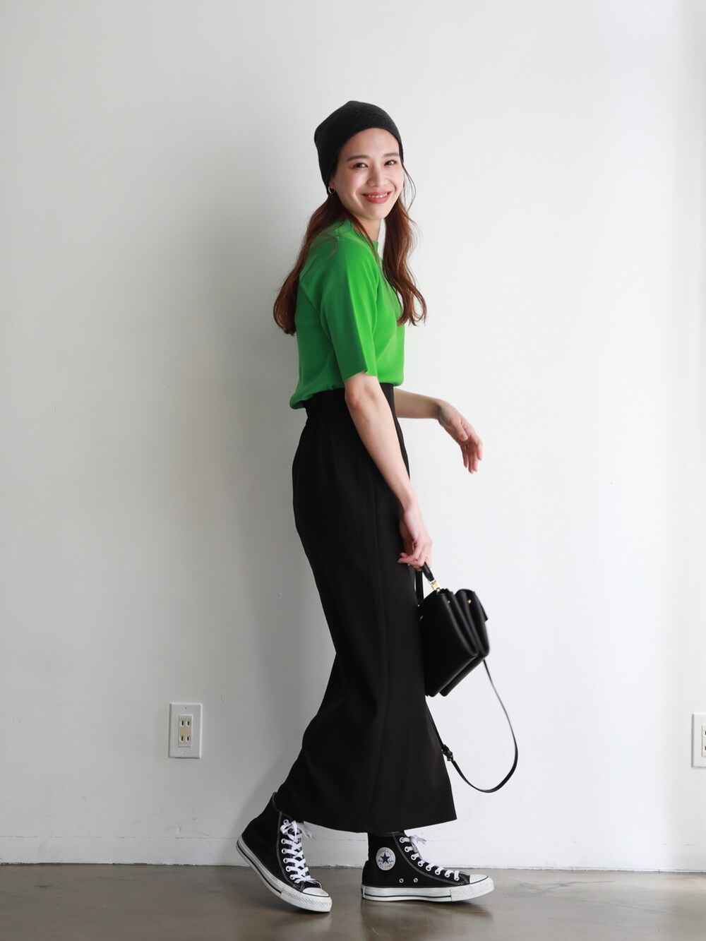 ブラック系のスニーカー、ブラック系のスカート、ブラック系のショルダーバッグを着用したレディースの春コーディネートの2枚目の写真