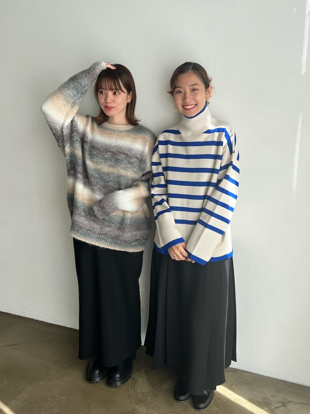 ブルー系のニット/セーター、ブラック系のスカート、ブラウン系のニット/セーターを着用したレディースの冬コーディネートの2枚目の写真