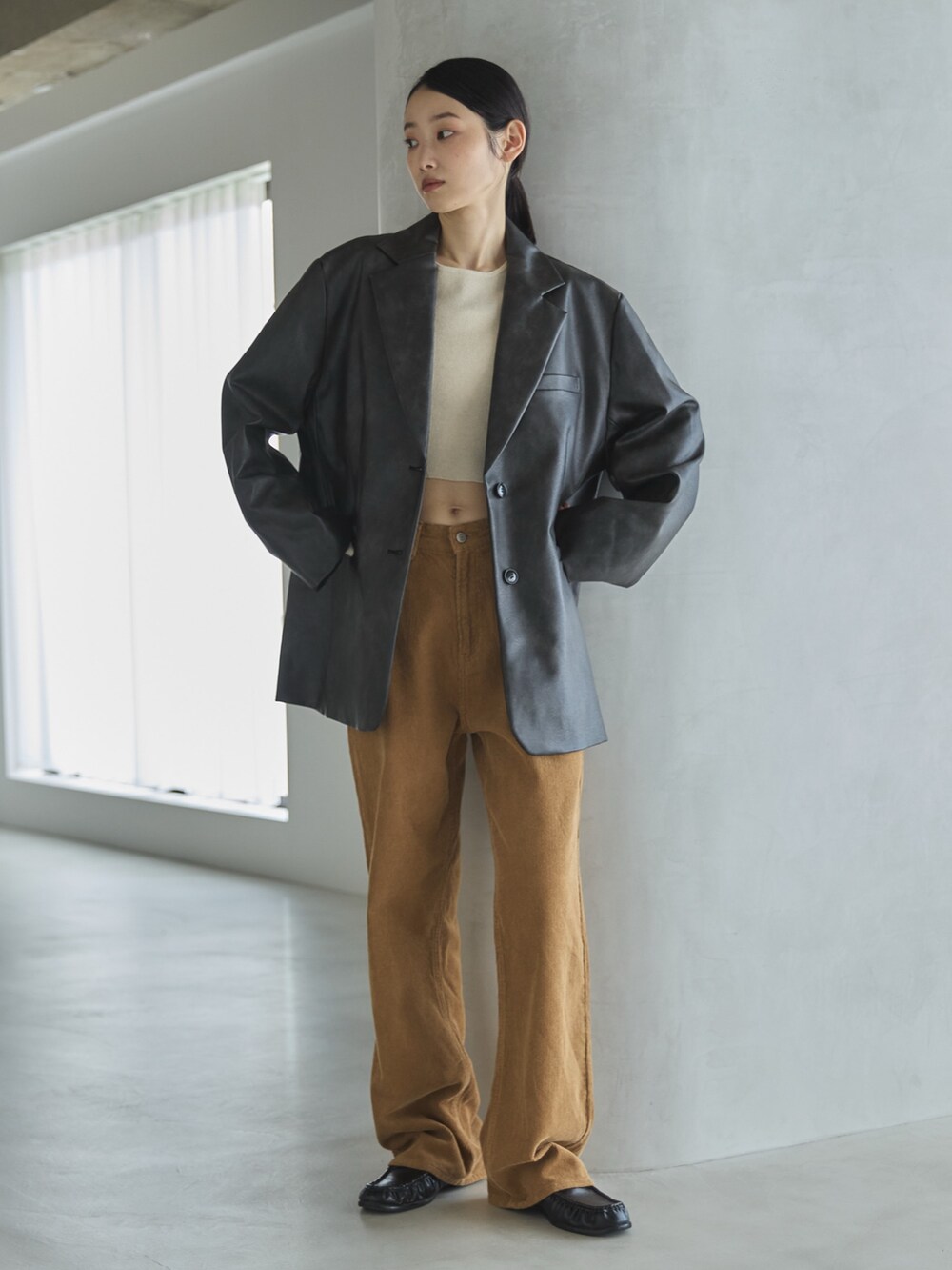 ホワイト系のニット/セーター、ブラック系のテーラードジャケット、イエロー系のその他パンツを着用したレディースの秋コーディネートの3枚目の写真