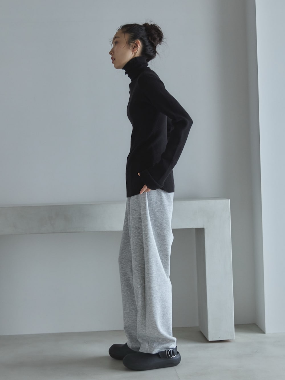 ブラック系のニット/セーター、グレー系のその他パンツ、ブラック系のサンダルを着用したレディースの秋コーディネートの2枚目の写真