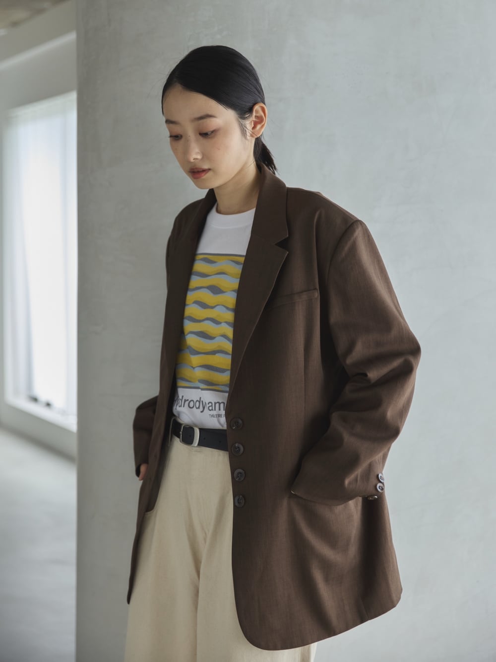 ホワイト系のデニムパンツ、ホワイト系のTシャツ/カットソー、ブラウン系のテーラードジャケットを着用したレディースの秋コーディネートの5枚目の写真