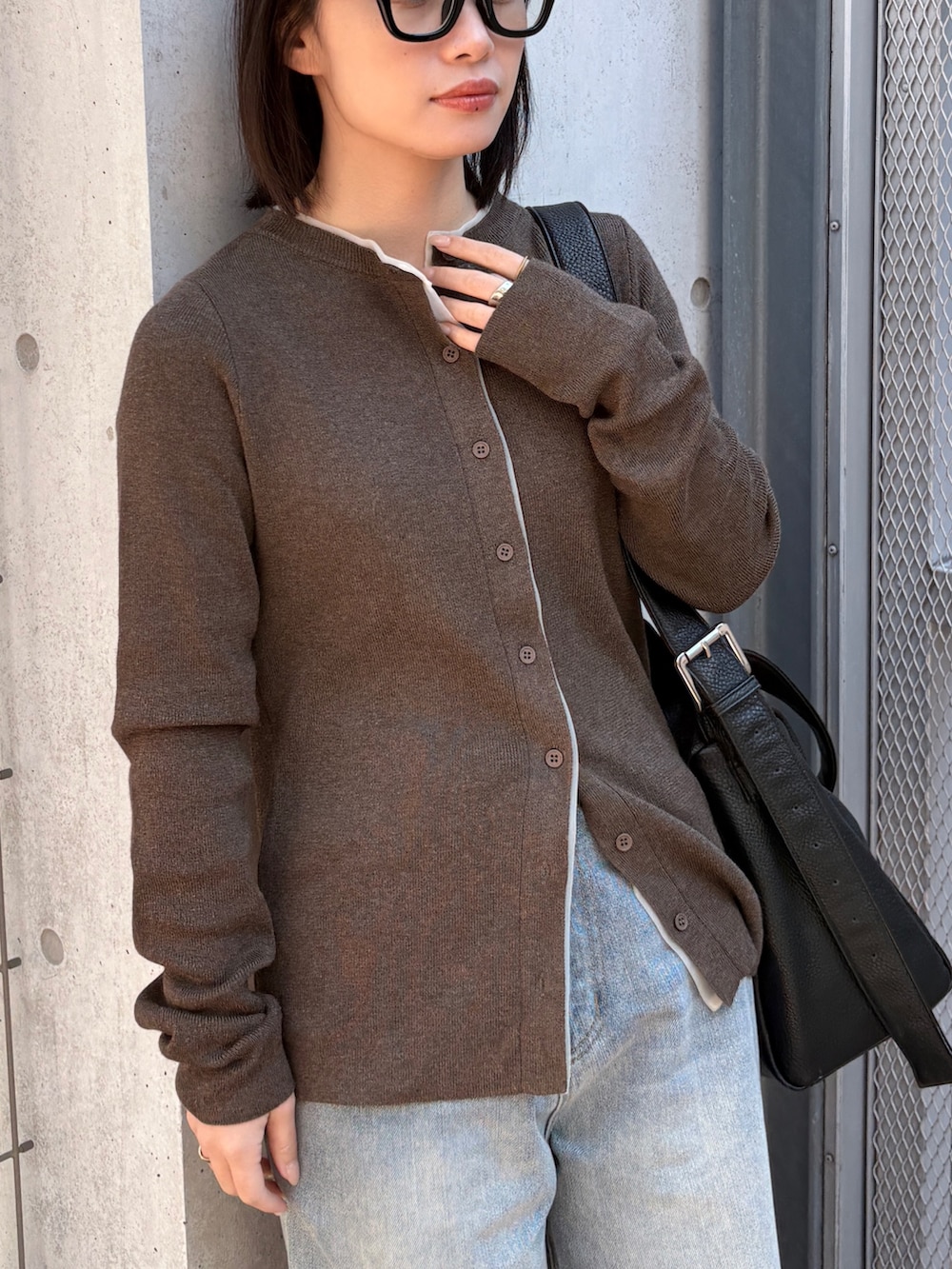 ブラウン系のカーディガン/ボレロ、ブルー系のデニムパンツ、ブラック系のショルダーバッグを着用したレディースの春コーディネートの4枚目の写真