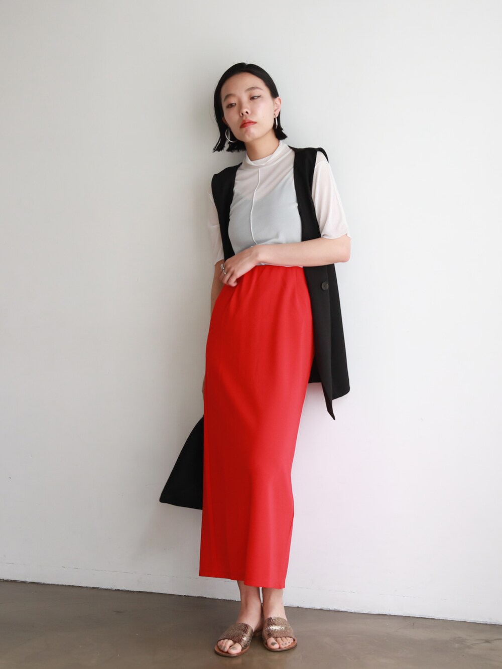ホワイト系のニット/セーター、ブラック系のショルダーバッグ、レッド系のスカートを着用したレディースの夏コーディネートの2枚目の写真