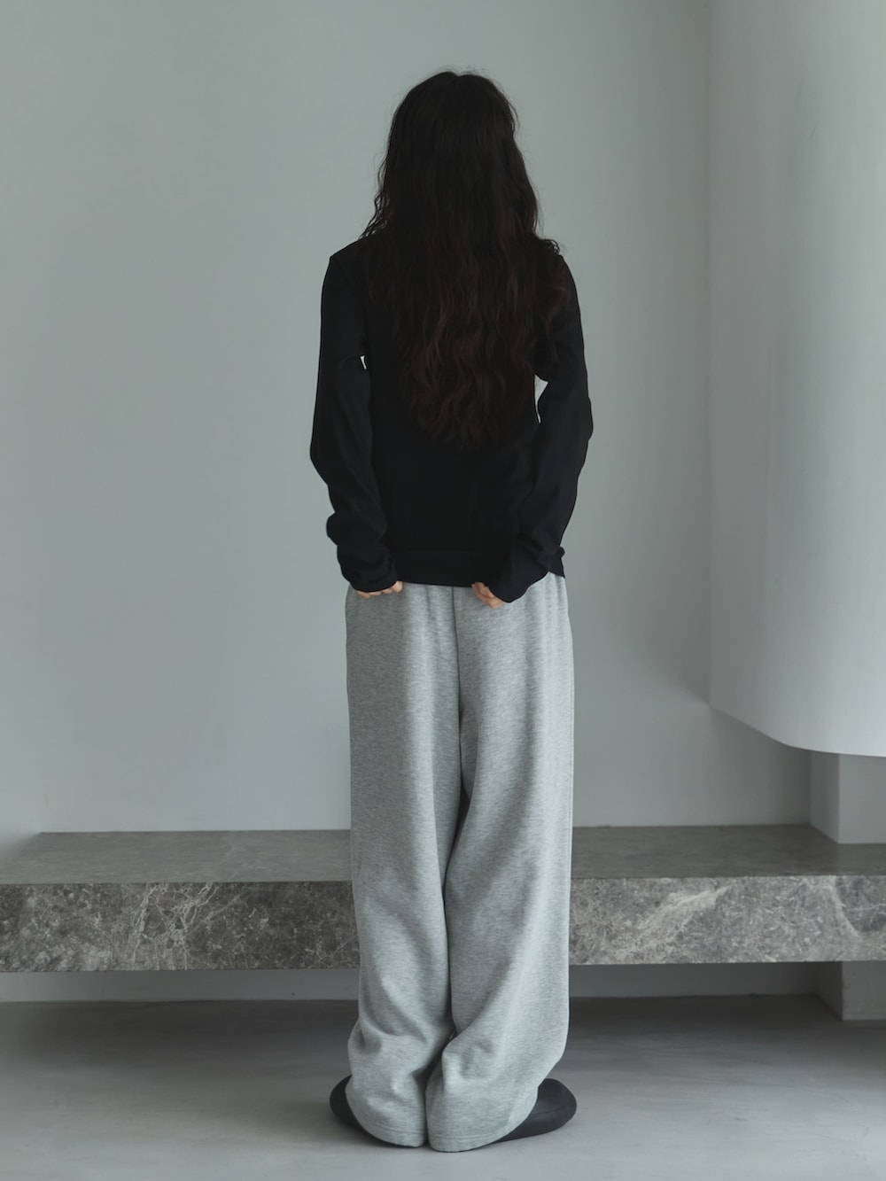 ブラック系のTシャツ/カットソー、グレー系のスウェットパンツ、ブラック系のサンダルを着用したレディースの秋コーディネートの3枚目の写真