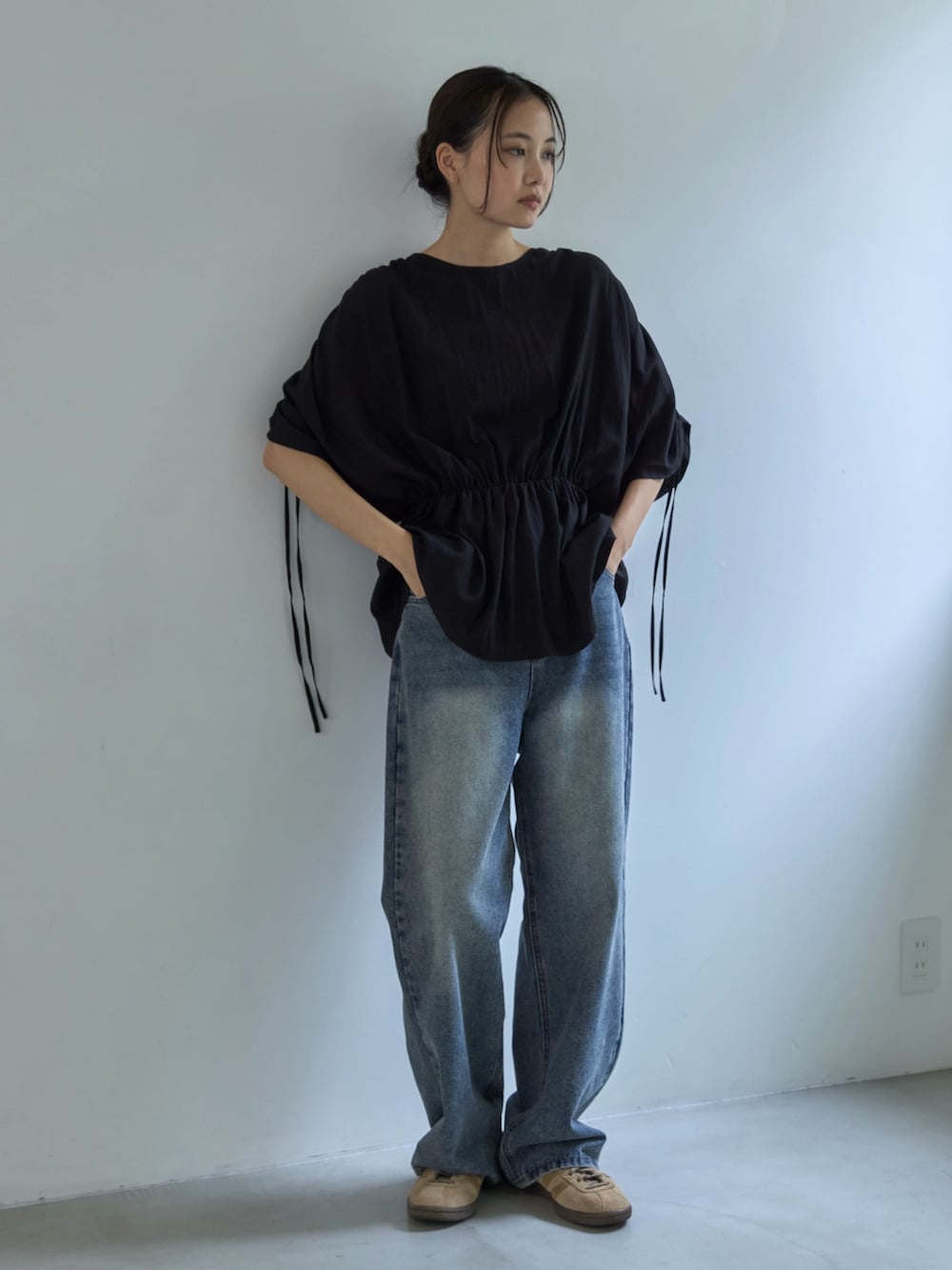 ブラック系のシャツ/ブラウス、ブルー系のデニムパンツ、ベージュ系のスニーカーを着用したレディースの夏コーディネートの2枚目の写真