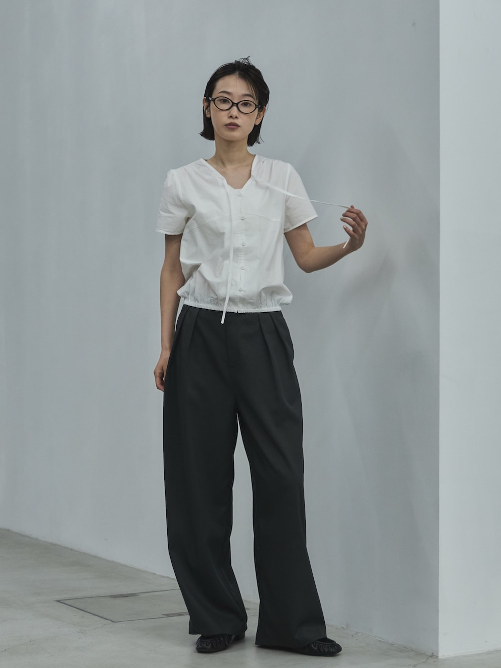 ホワイト系のシャツ/ブラウス、グレー系のスラックス、ブラック系のローファーを着用したレディースの夏コーディネートの3枚目の写真