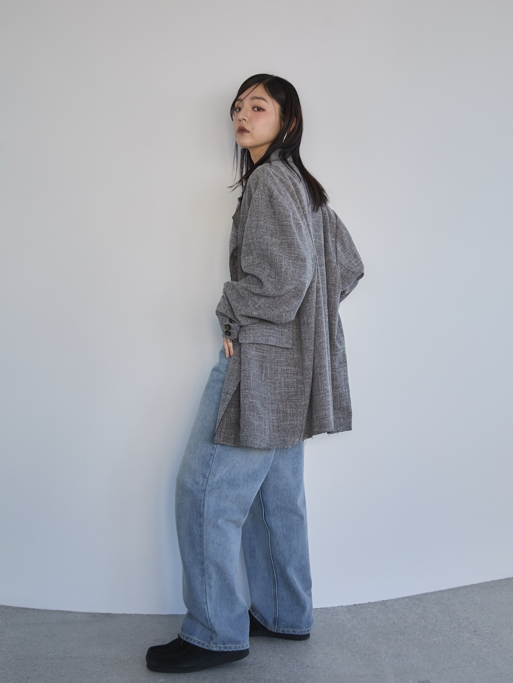 ブルー系のデニムパンツ、ブラック系のテーラードジャケット、ホワイト系のニット/セーターを着用したレディースの冬コーディネートの2枚目の写真