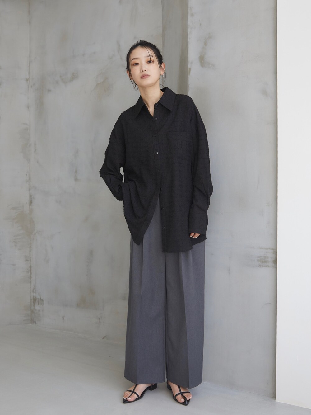 ブラック系のシャツ/ブラウス、グレー系のスラックス、ブラック系のサンダルを着用したレディースの夏コーディネートの2枚目の写真