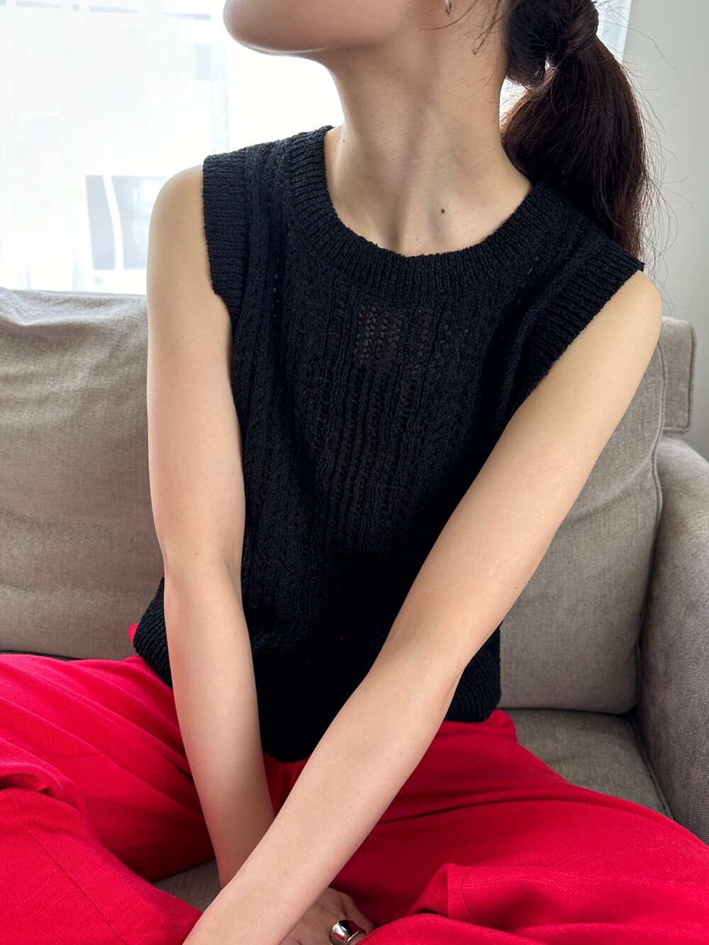 ブラック系のニット/セーター、レッド系のその他パンツ、ブラック系のサンダルを着用したレディースの夏コーディネートの3枚目の写真