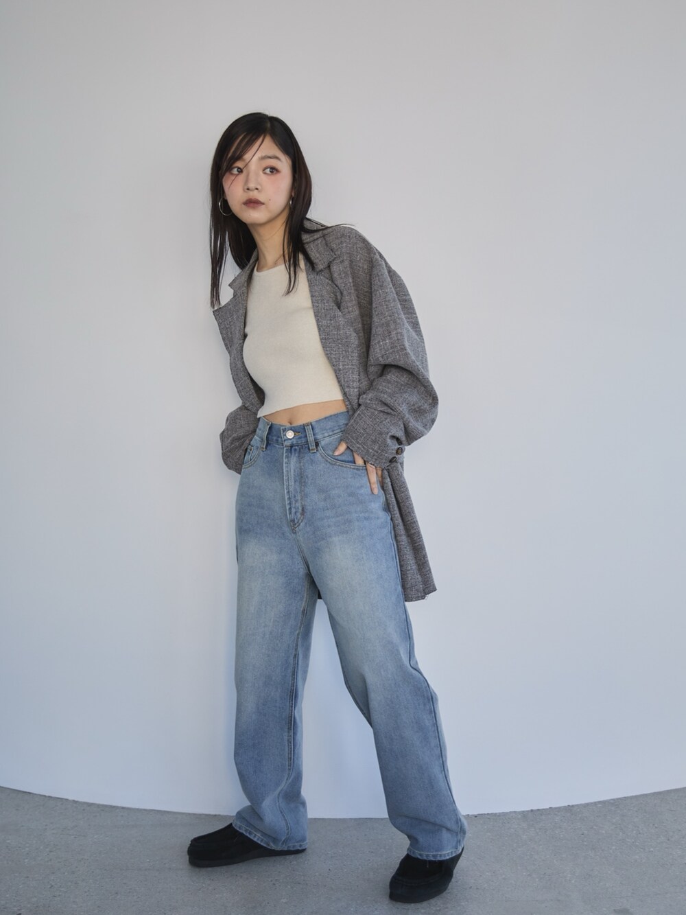 ブルー系のデニムパンツ、ブラック系のテーラードジャケット、ホワイト系のニット/セーターを着用したレディースの冬コーディネートの3枚目の写真