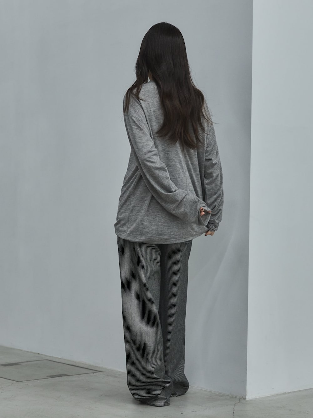 ブラック系のデニムパンツ、ブラック系のその他シューズ、グレー系のTシャツ/カットソーを着用したレディースの秋コーディネートの3枚目の写真