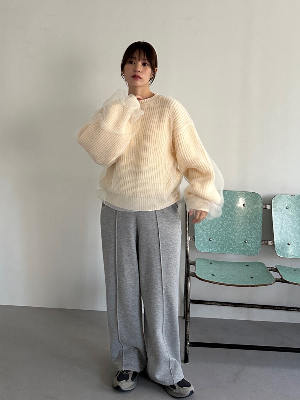 ホワイト系のニット/セーター、グレー系のスウェットパンツ、グレー系のスニーカーを着用したレディースの冬コーディネートの2枚目の写真