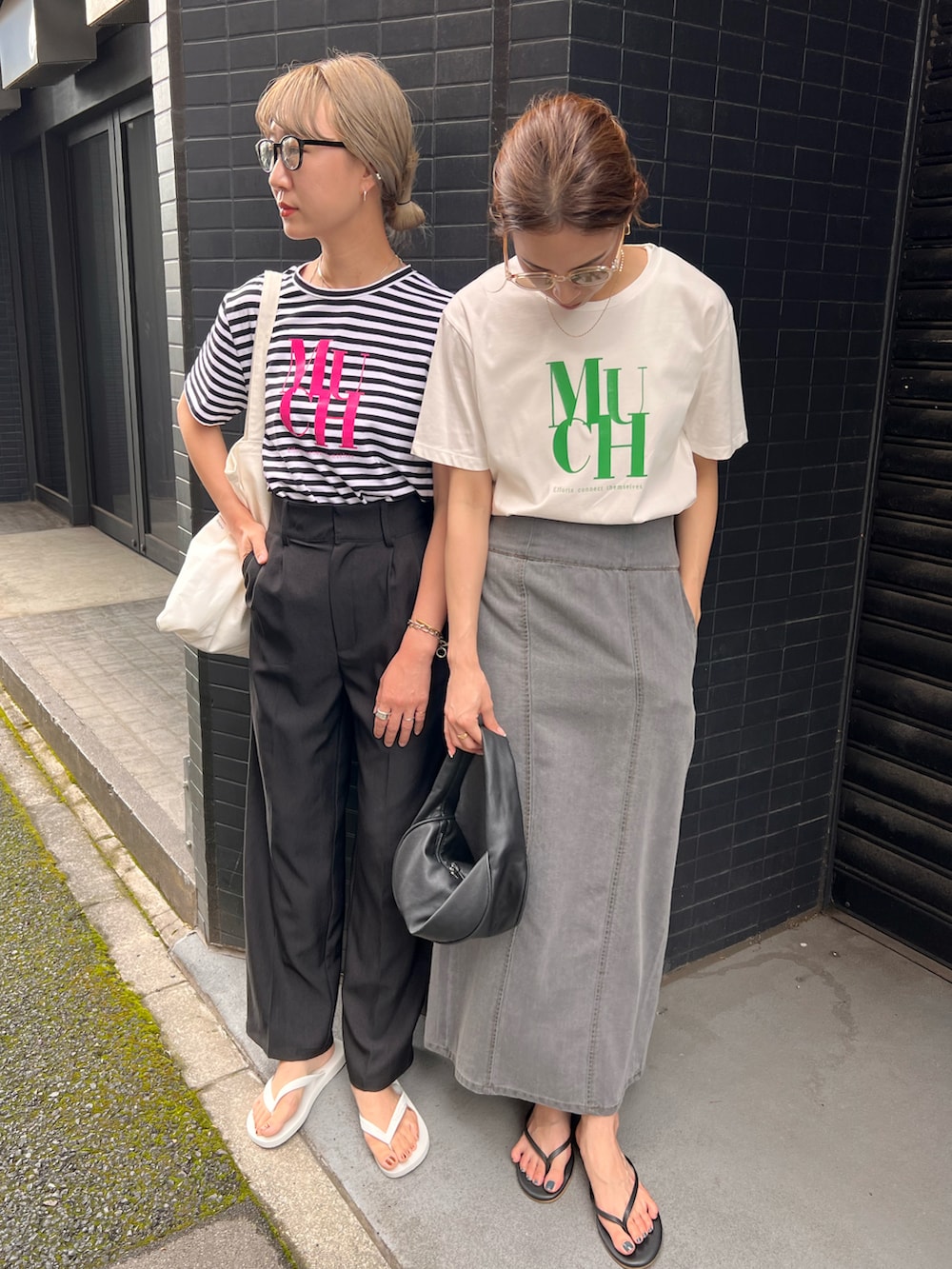ブラック系のハンドバッグ、ホワイト系のTシャツ/カットソー、ブラック系のサンダルを着用したレディースの夏コーディネートの2枚目の写真