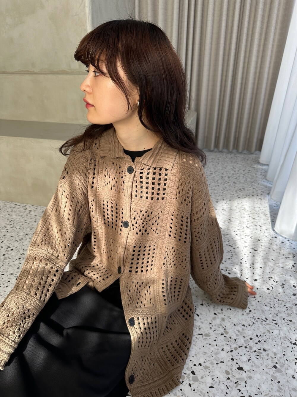 グリーン系のカーディガン/ボレロ、ブラック系のワンピース、ブラック系のスニーカーを着用したレディースの冬コーディネートの3枚目の写真