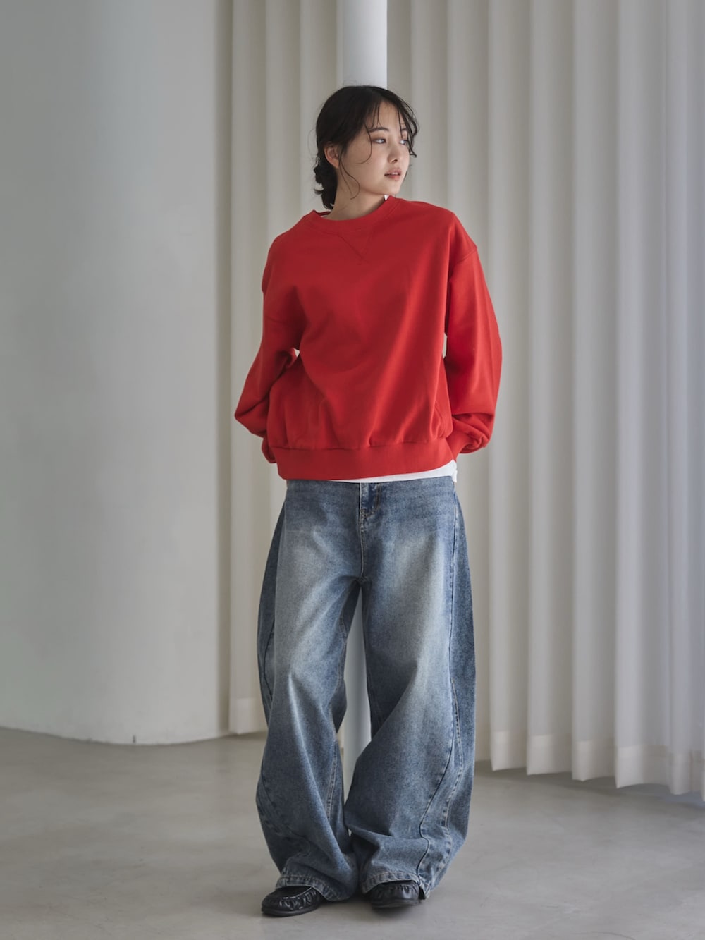 レッド系のスウェット、ホワイト系のTシャツ/カットソー、ブルー系のデニムパンツを着用したレディースの秋コーディネートの3枚目の写真