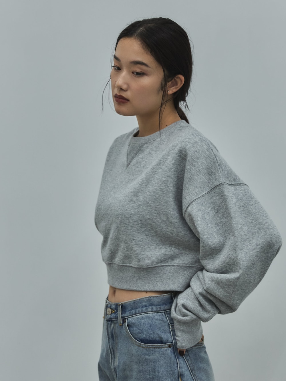 グレー系のスウェット、ブルー系のデニムパンツ、ベージュ系のその他シューズを着用したレディースの秋コーディネートの5枚目の写真
