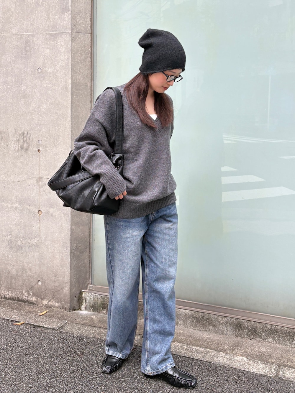 ブルー系のデニムパンツ、ブラック系のローファー、ブラック系のショルダーバッグを着用したレディースの秋コーディネートの2枚目の写真