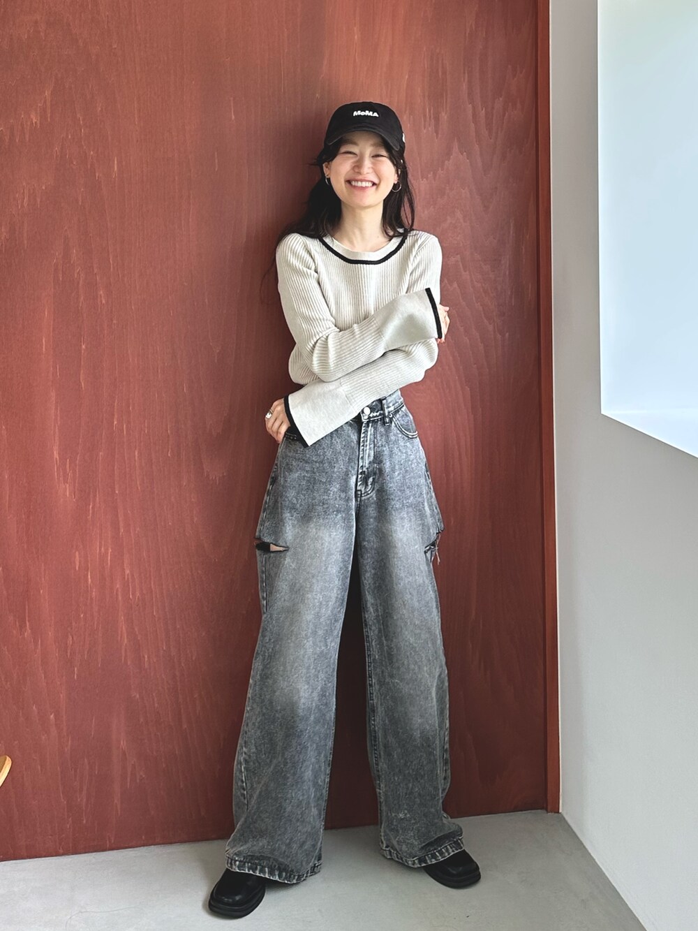 ブラック系のデニムパンツ、ブラック系のスリッポン、ホワイト系のニット/セーターを着用したレディースの秋コーディネートの2枚目の写真