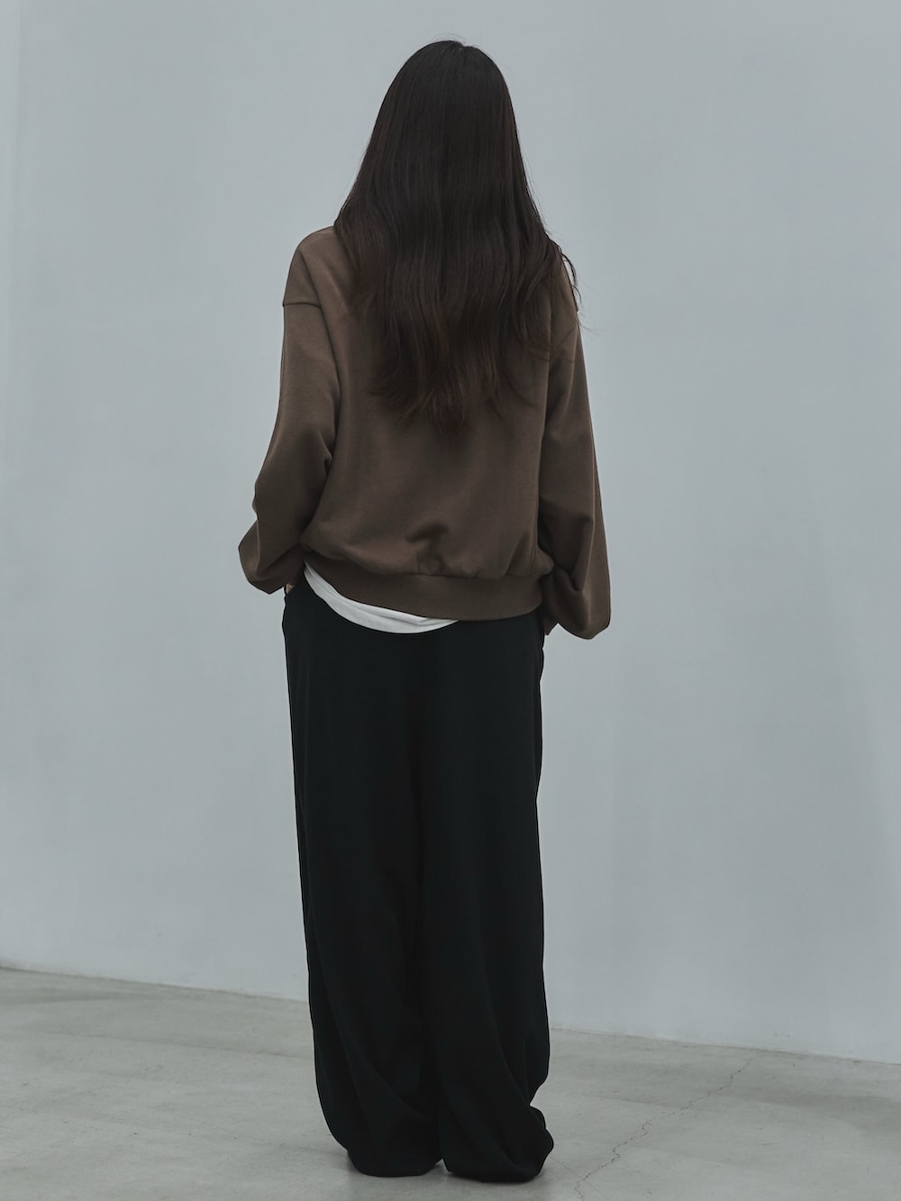 ブラック系のその他シューズ、ブラック系のスラックス、ホワイト系のTシャツ/カットソーを着用したレディースの秋コーディネートの3枚目の写真